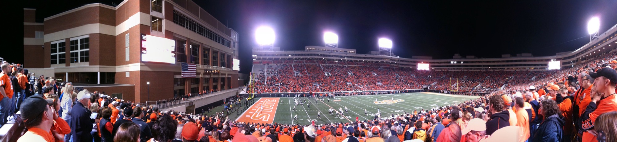 An archival panoramic photograph of fans at Boone Pickens Stadium at night